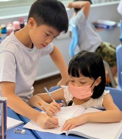 Let's Talk! 兩位學生在英語課堂中專注書寫練習，培養紮實的英語讀寫能力